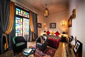 a bedroom with a bed and a chair and a window at Riad Star by Marrakech Riad in Marrakech