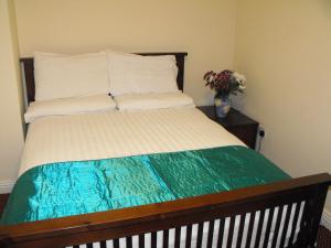 Un dormitorio con una cama con un jarrón de flores en Hazelbrook Lodge en Dublín