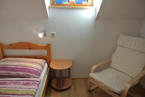ein kleines Zimmer mit einem Bett und einem Stuhl in der Unterkunft Bio-Bergbauernhof Möslhof in Aigen im Ennstal