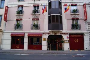 un bâtiment rose avec un hôtel dans une rue de la ville dans l'établissement Hôtel 1er Consul Rouen, à Rouen