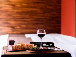 a table with a glass of wine and a tray of food at Restaurant & Inn ATSUSHI -Kanazawa- in Kanazawa