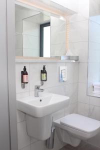 a white bathroom with a sink and a toilet at Baginbun Lodge in Fethard on Sea +17 photos