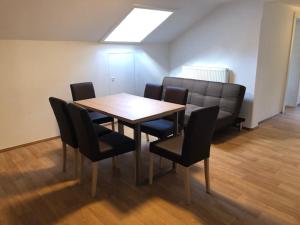 a dining room with a wooden table and black chairs at Kienburg in Matrei in Osttirol