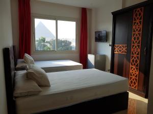 Postel nebo postele na pokoji v ubytování Sahara Pyramids Inn