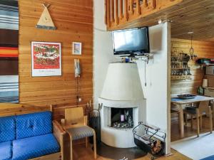 a living room with a blue couch and a fireplace at Holiday Home Ylläsmukka a 3 by Interhome in Äkäslompolo