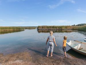 Holiday Home B by Interhome في بورفو: طفلين واقفين على شاطئ بحيرة مع قارب
