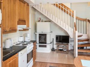 a kitchen with a stove top oven next to a staircase at Holiday Home Levin alppi 2 as 5 by Interhome in Sirkka