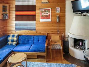 a living room with a blue couch and a fireplace at Holiday Home Ylläsmukka a 3 by Interhome in Äkäslompolo