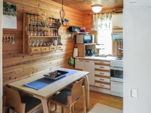 a kitchen with wooden walls and a table and chairs at Holiday Home Ylläsmukka a 3 by Interhome in Äkäslompolo +8 photos