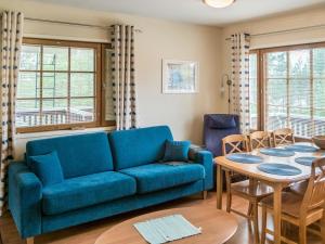 a living room with a blue couch and a table at Holiday Home Levin alppi 2 as 5 by Interhome in Sirkka