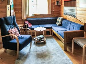 a living room with a blue couch and two chairs at Holiday Home Ylläsmukka a 3 by Interhome in Äkäslompolo