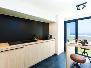 a kitchen with wooden cabinets and a counter with a table at Holiday Home Creativo by Interhome in La Herradura +14 photos