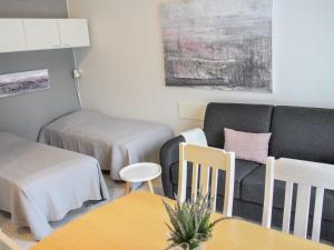 - un salon avec un canapé, une table et des chaises dans l'établissement Holiday Home Kanerva 202 by Interhome, à Äkäslompolo