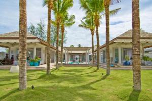 una casa con palmeras en el patio en Mia Beach, beach villa and events, en Chaweng