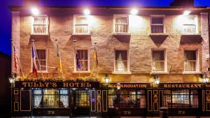 un grande edificio con bandiere di fronte ad esso di Tully's Hotel a Castlerea