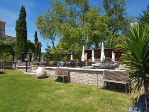a backyard with a fountain with chairs and trees at Le Domaine Du Colombier in Malataverne