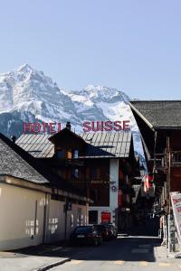 a hotel with a snow covered mountain in the background at Hotel Suisse in Champéry