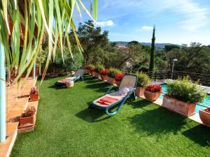 a row of chaise lounges on the grass near a pool at Holiday Home Gloria by Interhome in Calonge