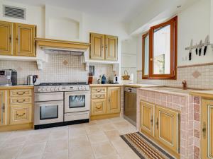 a kitchen with wooden cabinets and a stove top oven at Villa Caliopa by Interhome in Grasse