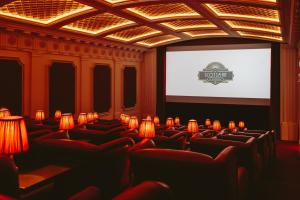 a cinema room with red chairs and a screen at The Scotsman Hotel in Edinburgh