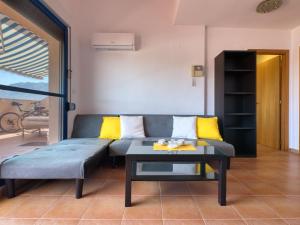 ein Wohnzimmer mit einem Sofa und einem Tisch in der Unterkunft Apartment La Marjal-3 by Interhome in Denia