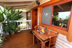 een houten veranda met een houten tafel en stoelen bij The Beautiful Cabins in Rosh Pinna