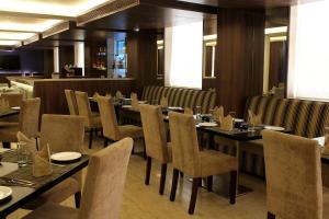 a dining room with long tables and chairs at The Roa Hotel in Mumbai