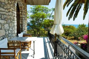 a patio with an umbrella and a table and chairs at Villa Petra in Kalamaki Messinia