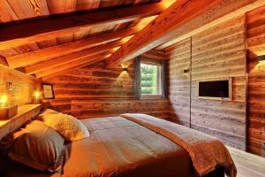 a bedroom with a bed in a log cabin at Chalet Luxe piscine et spa 18 personnes serrechevalierholidays in Le Monêtier-les-Bains
