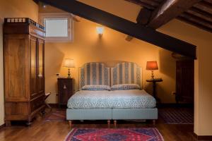 a bedroom with a bed with a blue bedspread at Piazza Nova Guest House in Ferrara