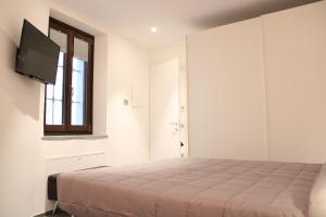 a bedroom with a bed and a flat screen tv at L'Atelier du Temps - Maison Maillet in Aosta
