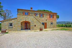 an old stone house with a driveway in front of it at Villa dei Vini by PosarelliVillas in Terontola