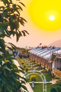 Blick auf ein Gebäude mit Garten in der Unterkunft Rawai Luxury Tents Pushkar in Pushkar