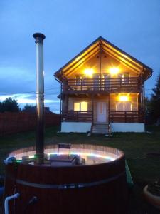 ベリシュにあるPanorama Apuseniの夜間は庭にホットタブ付きのログキャビンを利用できます。