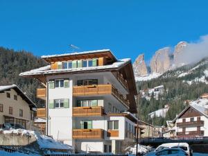 a building with wooden balconies and a mountain at Casa Soraruf in Campitello di Fassa