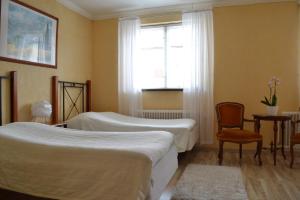 1 Schlafzimmer mit 2 Betten, einem Fenster und einem Stuhl in der Unterkunft Hotell City in Hässleholm