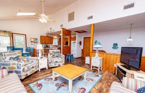 a living room with a table and a tv at Misty Blue in Corolla