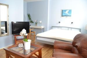 ein Wohnzimmer mit einem Bett, einem Sofa und einem Tisch in der Unterkunft Hotell City in Hässleholm