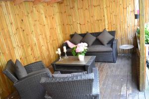 eine Terrasse mit 2 Korbstühlen und einem Tisch mit Blumen in der Unterkunft Hotell City in Hässleholm
