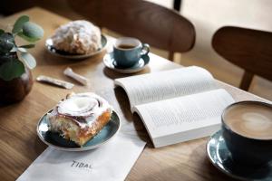 a table with a cup of coffee and a pastry and a book at Monterey Plaza Hotel & Spa in Monterey