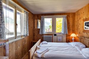 Cette chambre en bois comprend un grand lit. dans l'établissement Chalet Speciale - Celerina, à Celerina
