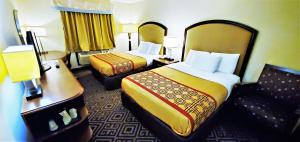 a hotel room with two beds and a desk at Travel Inn and Suites- Sikeston Miner I-55 exit-67 in Sikeston