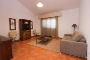 uma sala de estar com um sofá e uma televisão em Casa do Feitor - Monte da Graça em Elvas
