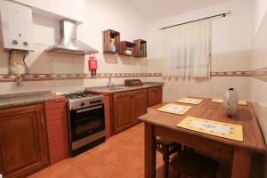 a kitchen with a wooden table and a stove at Casa do Feitor - Monte da Graça in Elvas