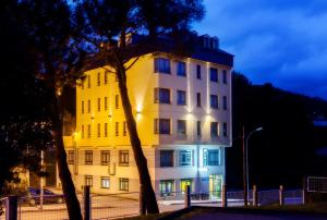 a white building with a tree in front of it at Hotel San Briz in A Pontenova