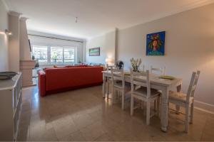 a living room with a table and a red couch at Farmers Market Vila Apartment in Cascais