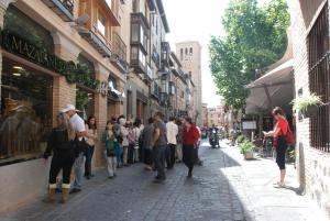a group of people standing outside of a store on a street at Apartamento Judería in Toledo
