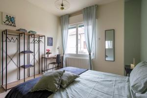 1 dormitorio con cama, escritorio y ventana en Dante7 by Welc(H)ome, en Treviso