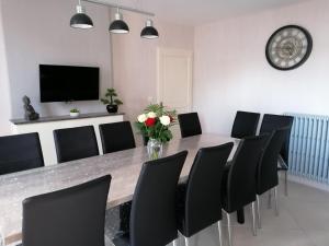 a dining room with a long table and black chairs at Le Bacchus in Chablis