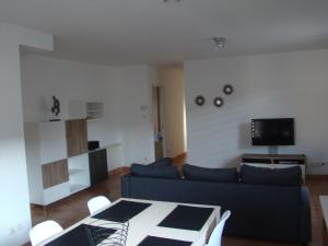 a living room with a blue couch and a tv at Maison confortable dans le Périgord pourpre in Lamonzie-Saint-Martin